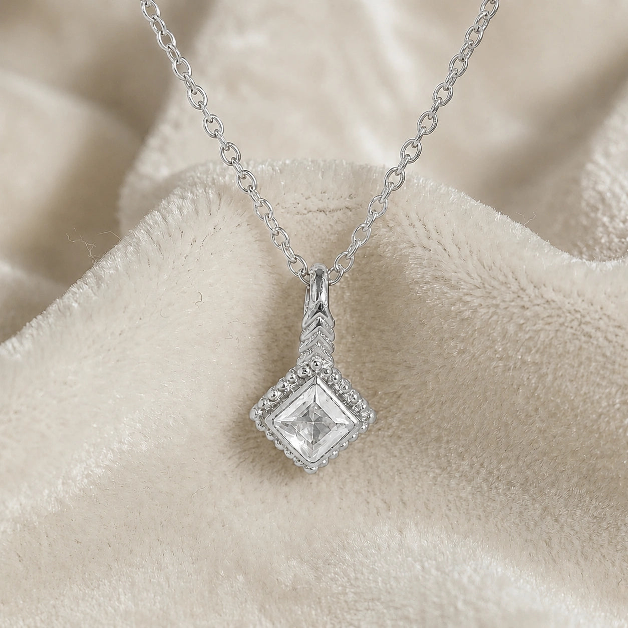 Birthstone_necklace_in_sterling_silver_with_square_cut_cz_pendant_in_front_angle_view_on_soft_white_fabric_background
