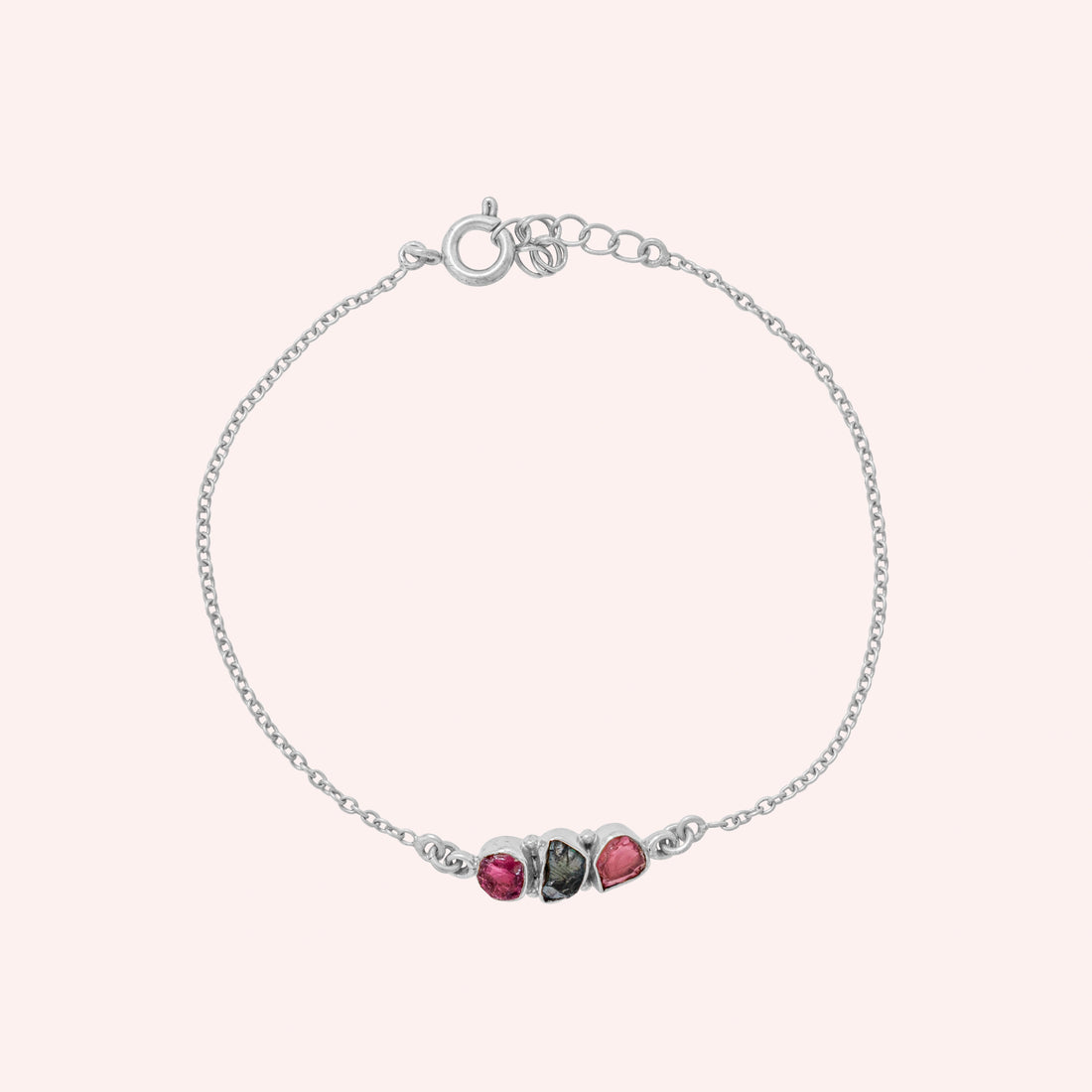 Chain_bracelet_in_gold_plated_silver_with_pink_and_green_tourmaline_stones_at_front_angle_view_on_solid_pink_background
