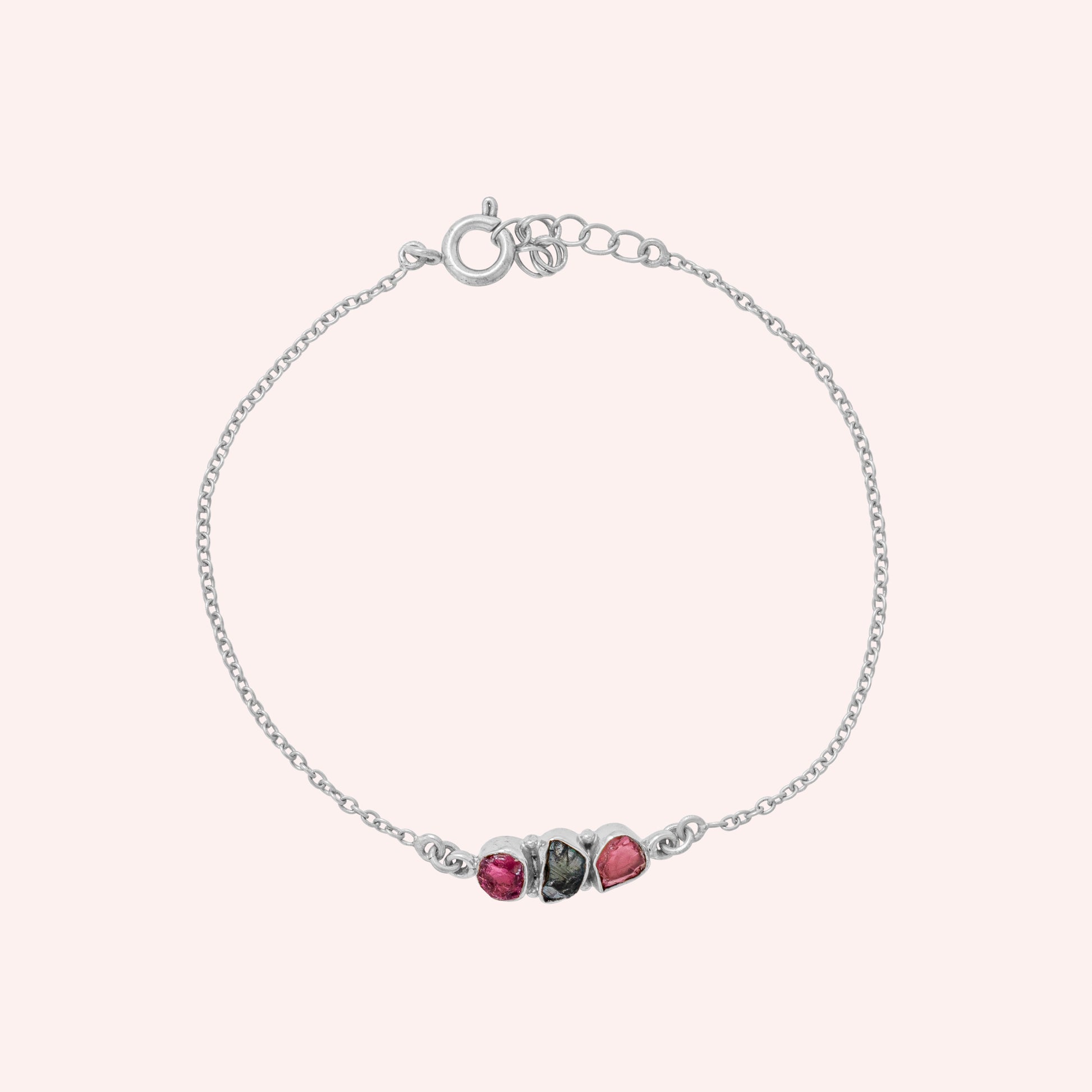 Chain_bracelet_in_sterling_silver_with_pink_and_green_tourmaline_stones_at_front_angle_view_on_solid_pink_background