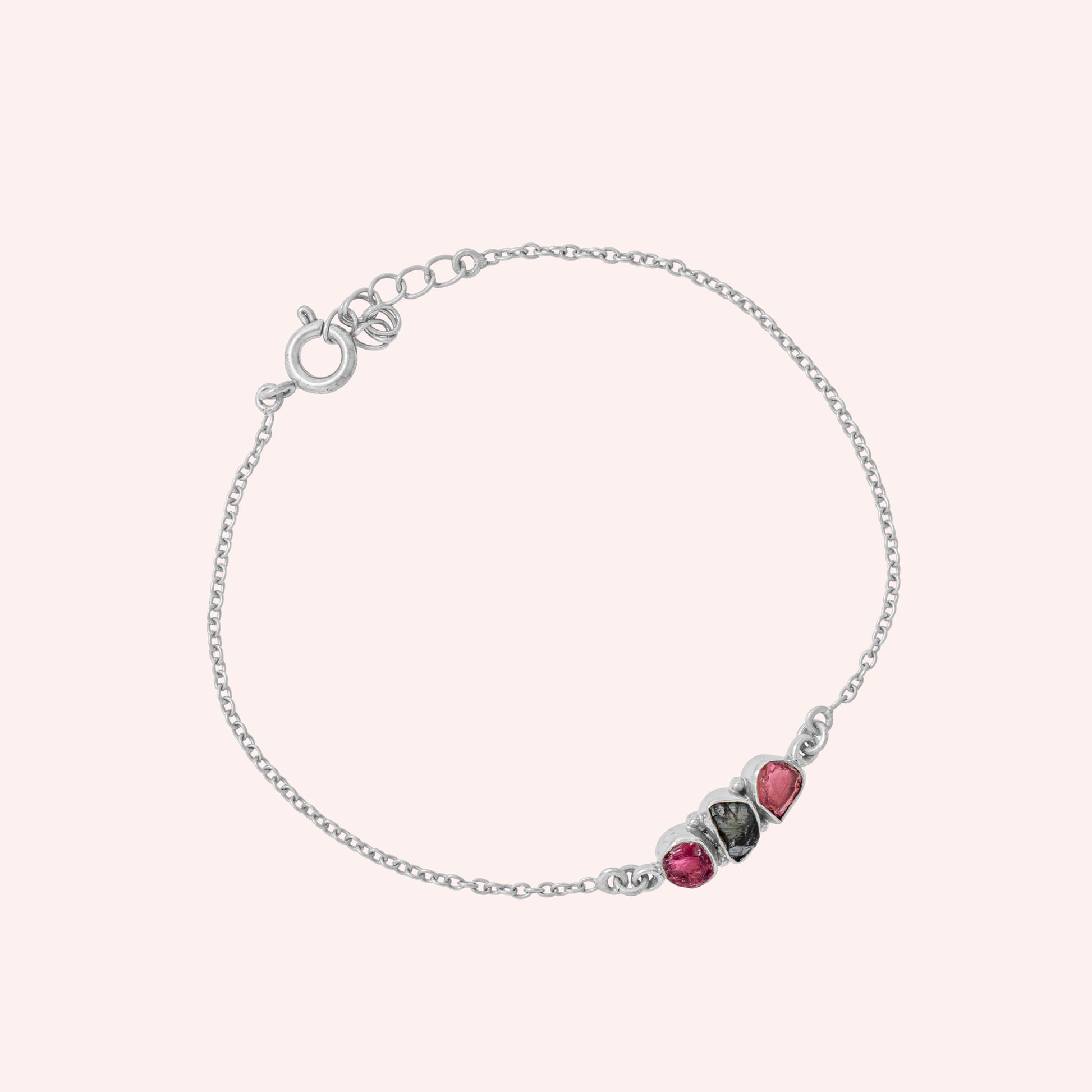 Chain_bracelet_in_sterling_silver_with_pink_and_green_tourmaline_stones_at_slight_angle_view_on_solid_pink_background