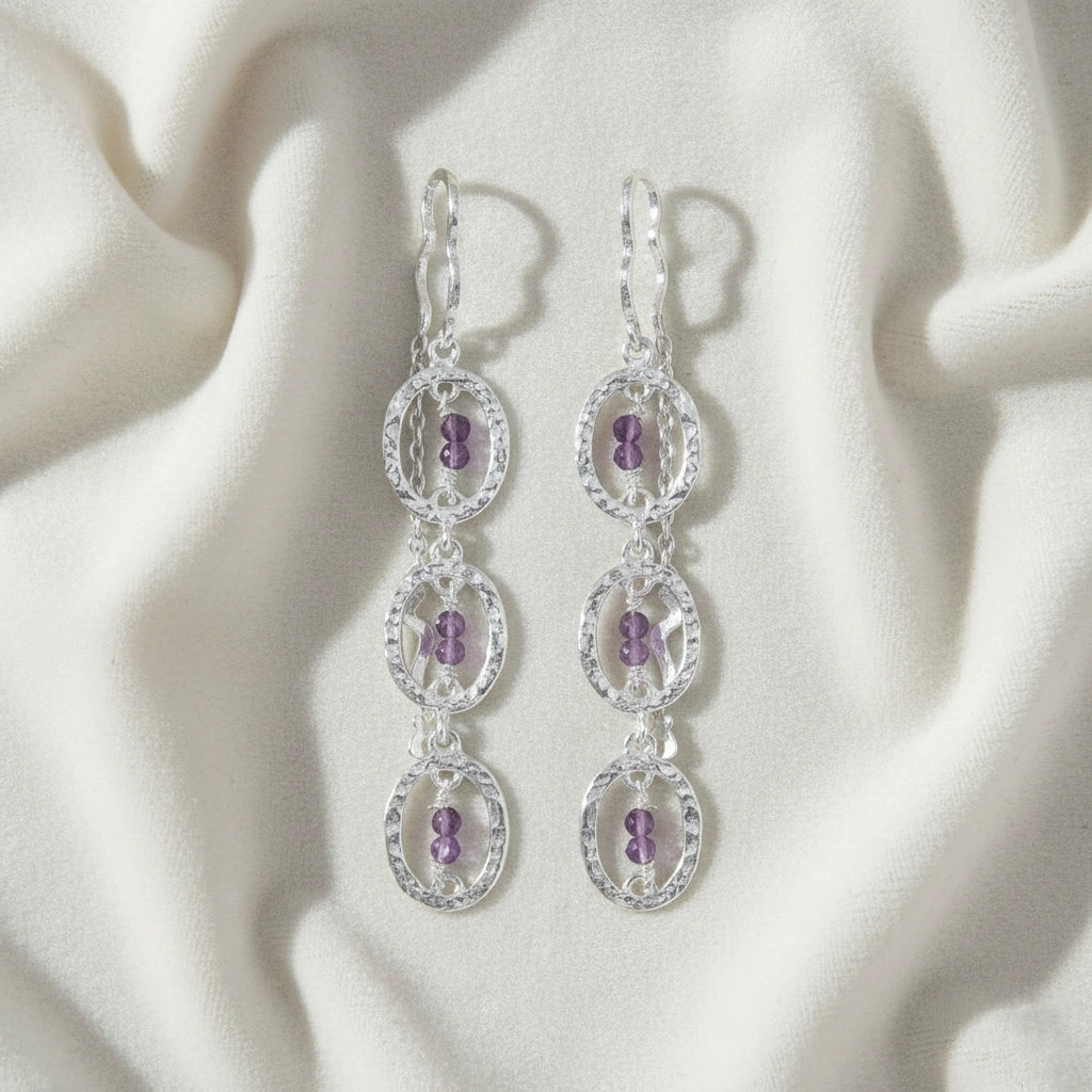 front_view_chain_link_earrings_with_hammered_silver_earrings_featuring_purple_beads_on_soft_fabric_background_flat_lay_angle