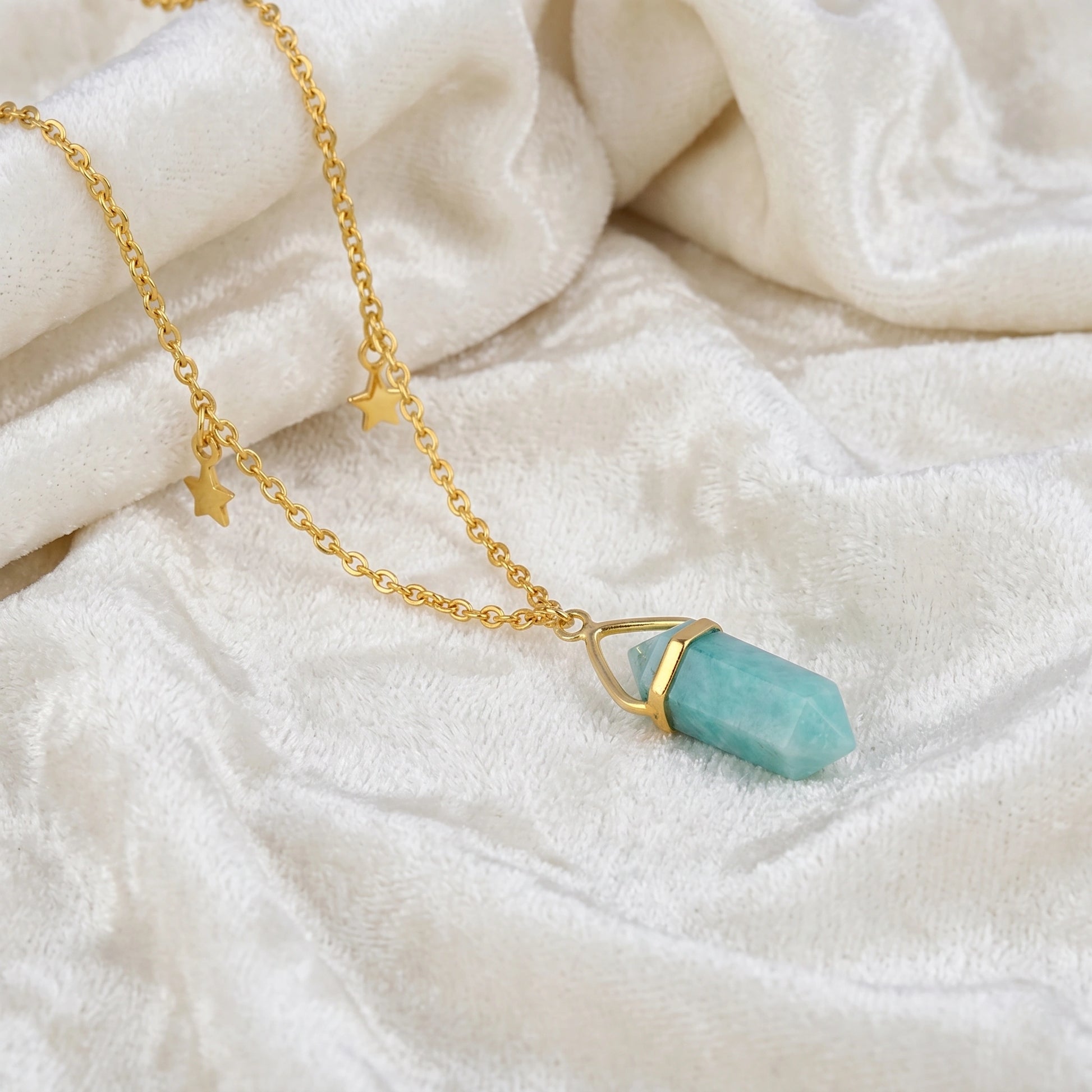 Charm_necklace_in_slightly_angled_view_with_gold_plated_silver_chain_star_charms_and_amazonite_stone_on_soft_fabric_background