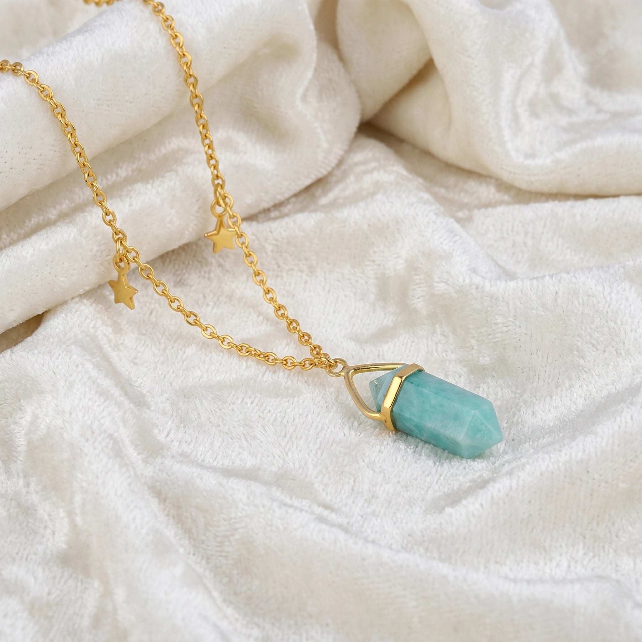 Charm_necklace_in_slightly_angled_view_with_gold_plated_silver_chain_star_charms_and_amazonite_stone_on_soft_fabric_background