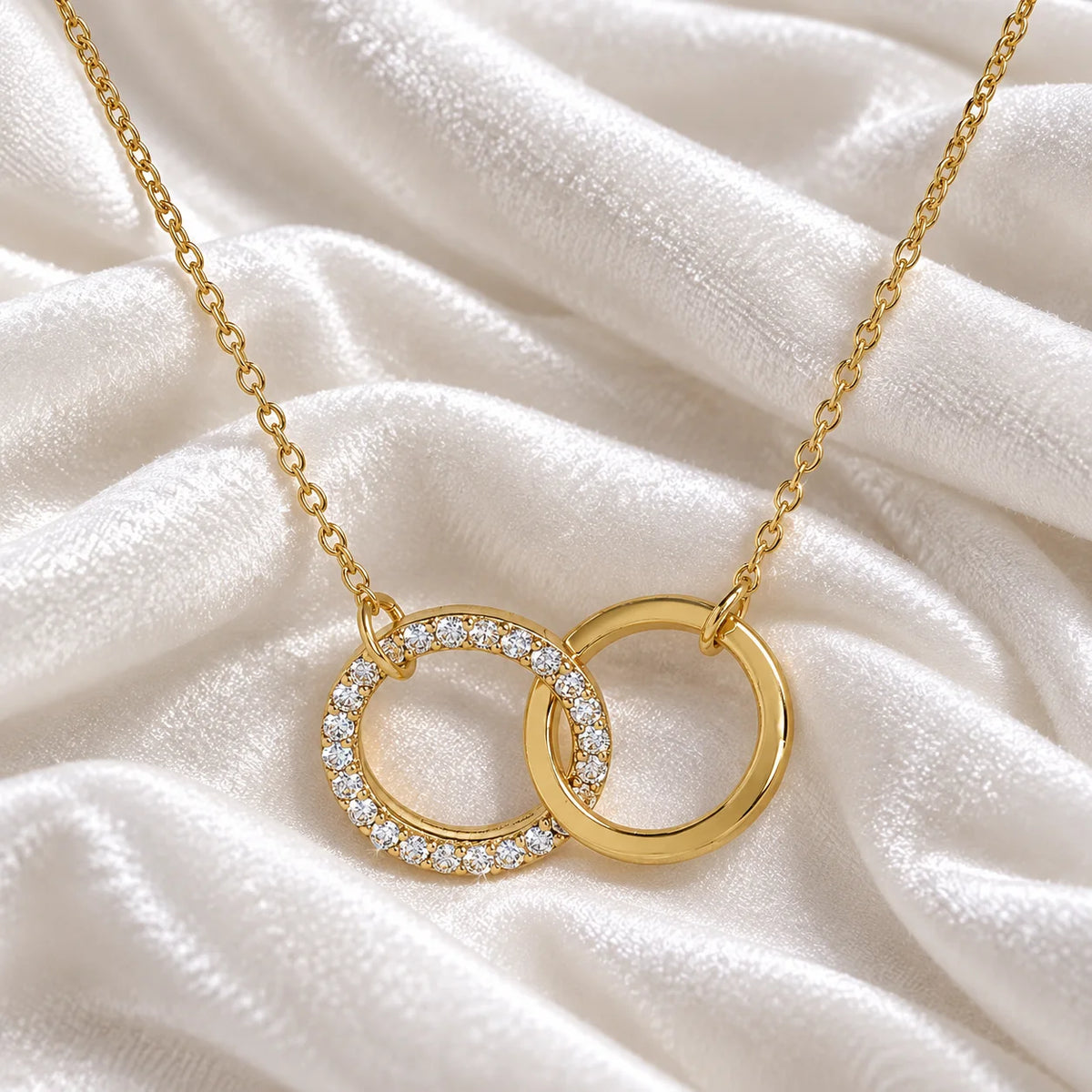 Charm_necklace_in_gold_plated_silver_with_interlock_circles_and_lab_grown_diamonds_at_front_angle_view_on_soft_fabric_background