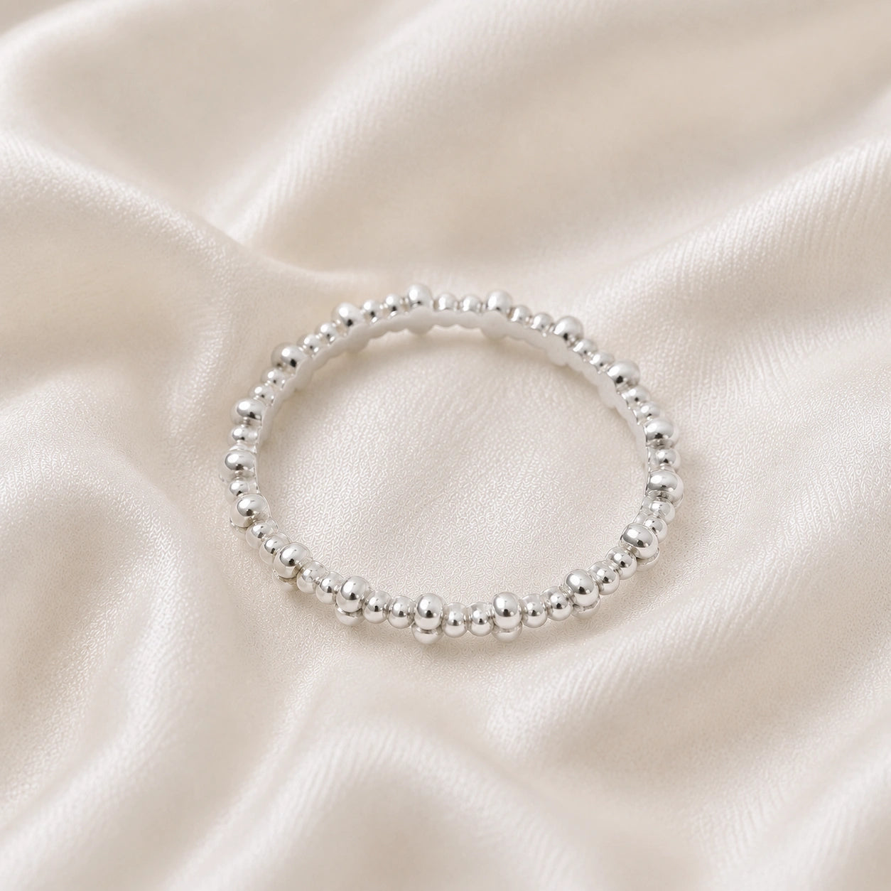 Minimal_ring_in_sterling_silver_at_front_angle_on_soft_fabric_background