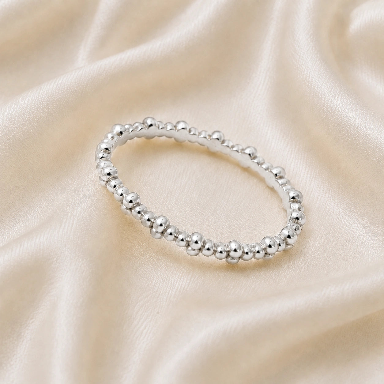 Minimal_ring_in_sterling_silver_at_slightly_angled_on_soft_fabric_background