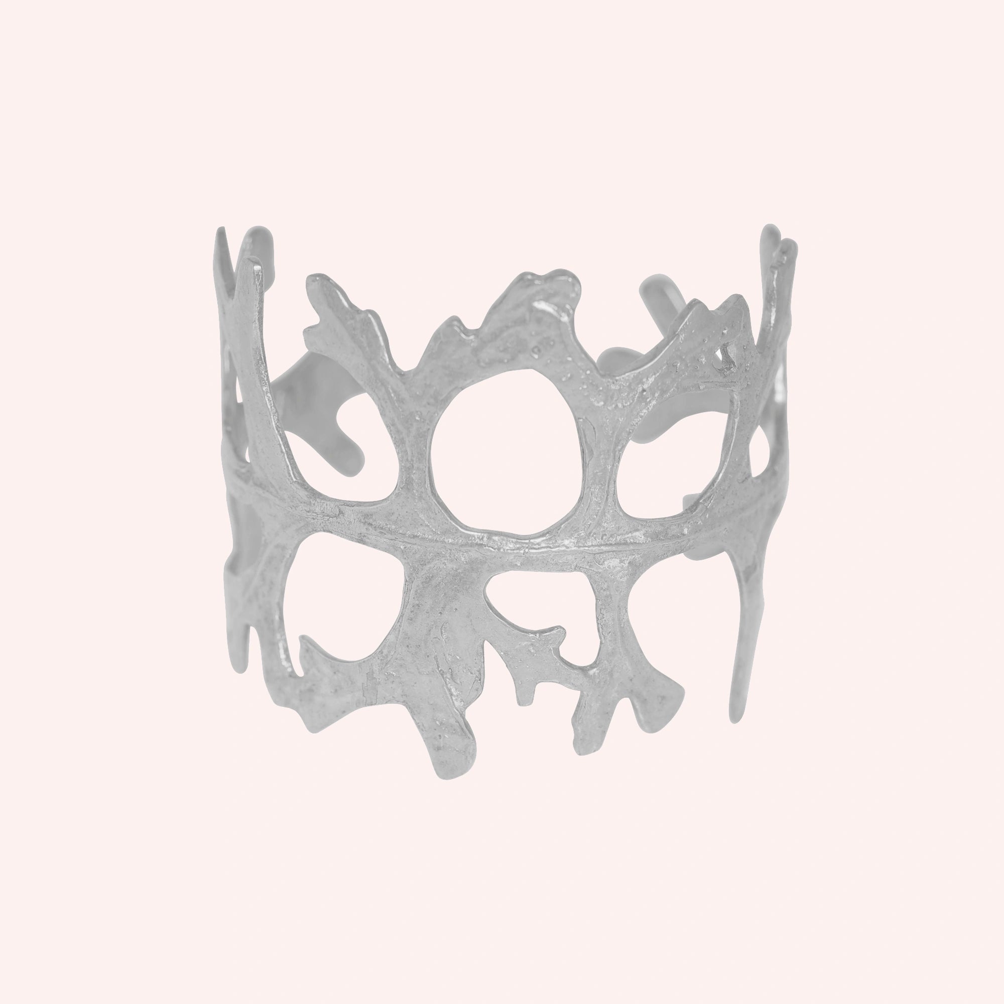 Chunky_bracelet_in_sterling_silver_showing_openwork_organic_adjustable_cuff_design_at_front_view_on_solid_pink_background