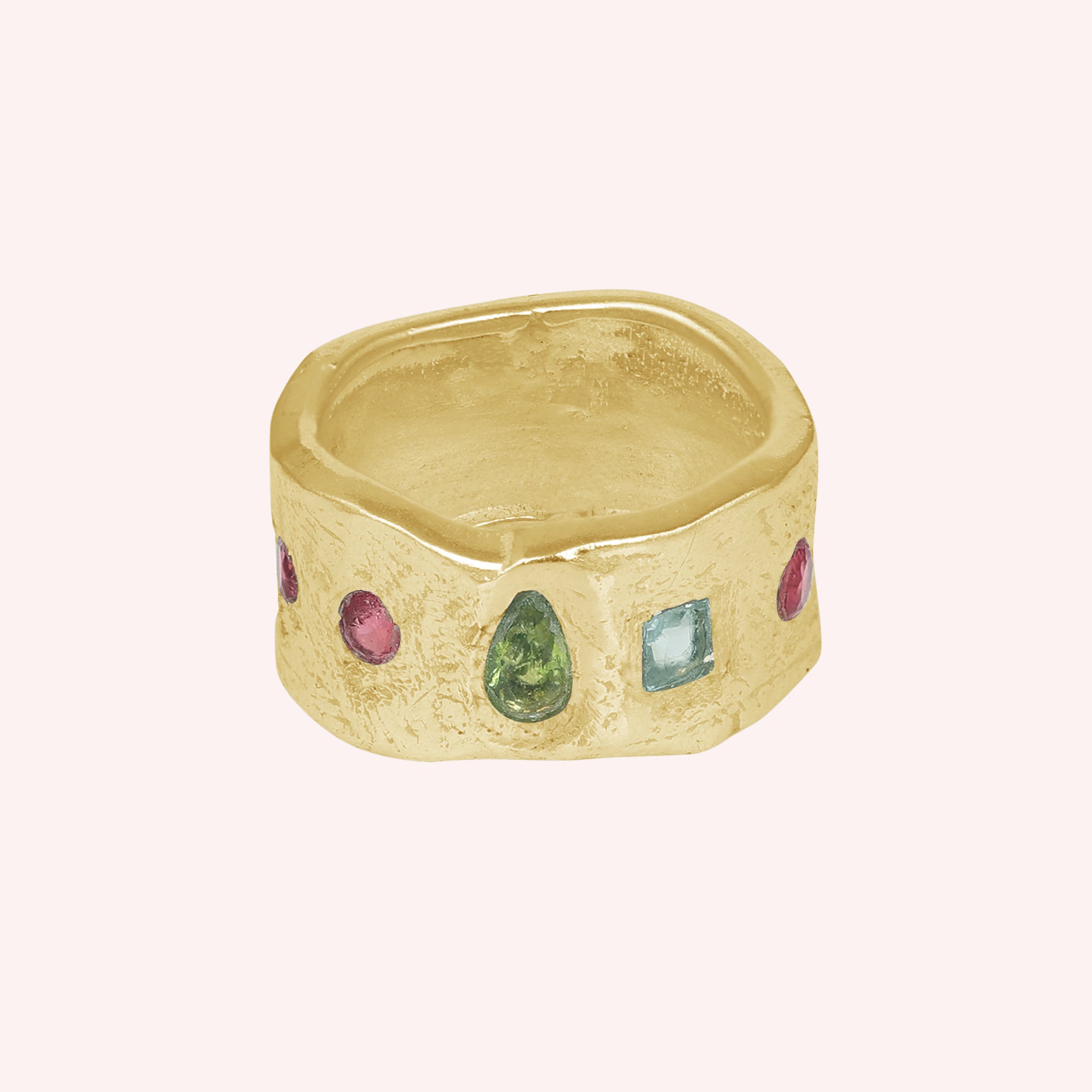 Chunky_ring_in_gold_plated_silver_at_front_angle_with_pink_tourmaline_peridot_and_blue_topaz_stones_on_a_solid_pink_background
