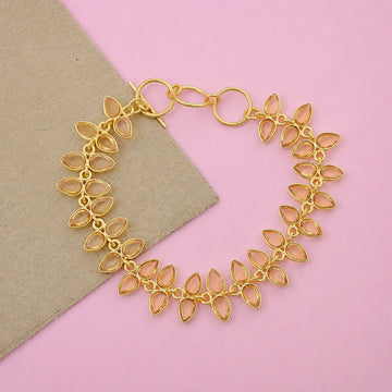 Citrine_bracelet_in_gold_plated_silver_with_leaf_shape_citrine_design_at_front_angle_view_on_pink_background