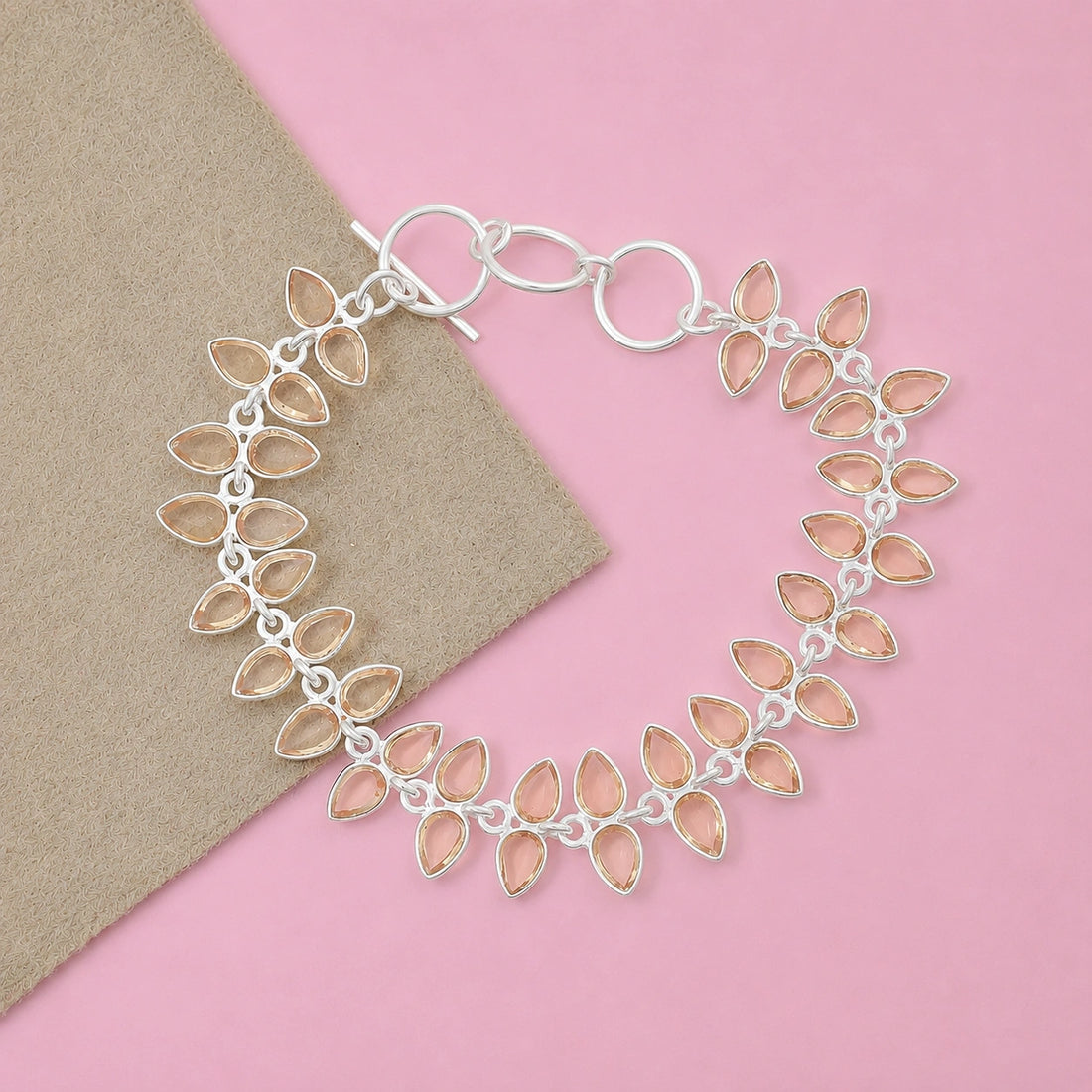 Citrine_bracelet_in_gold_plated_silver_with_leaf_shape_citrine_design_at_front_angle_view_on_pink_background