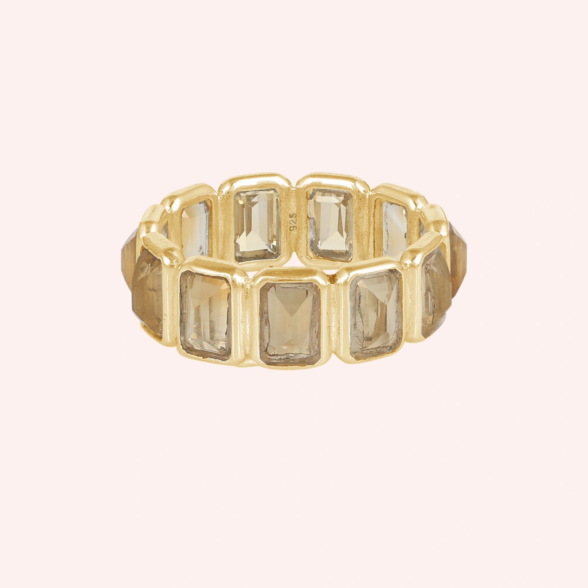 Horizontal shot of a sterling silver citrine ring on a light pink background showcasing rectangular citrine stones.