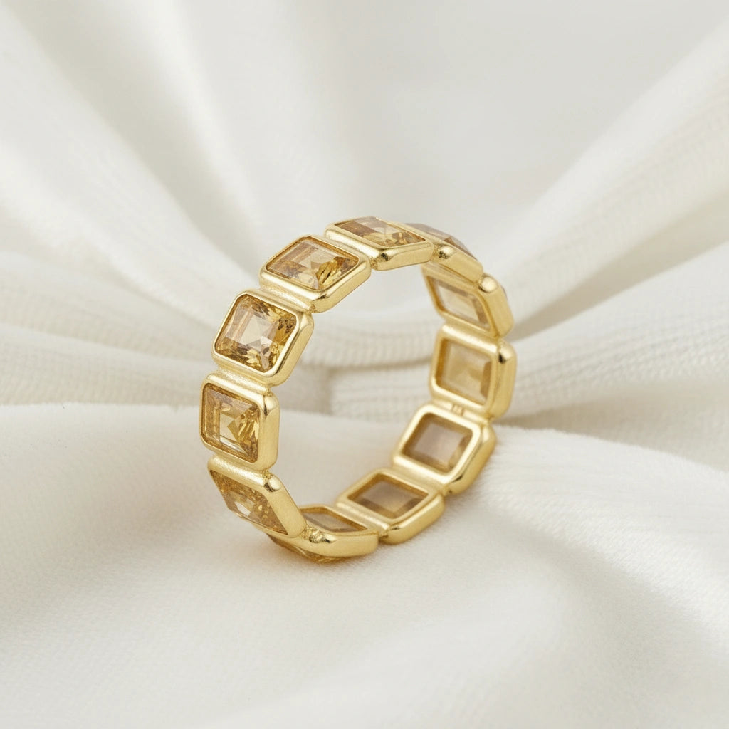 Angled close up shot of a gold-plated sterling silver citrine ring on a white silky background showcasing rectangular stones