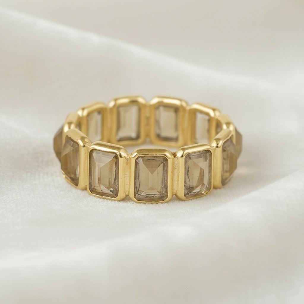 Horizontal close up shot of a gold-plated sterling silver citrine ring on a white cloth background with rectangular citrine stones
