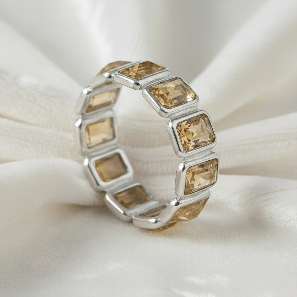 Angled close up shot of a sterling silver citrine ring on a white velvet fabric background showcasing rectangular citrine stones.
