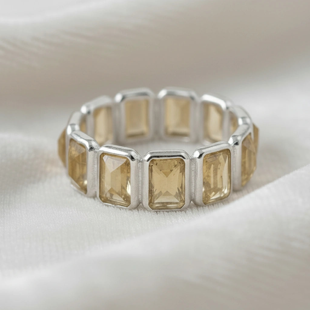 Angled close up shot of a sterling silver citrine ring on a white velvet cloth background showcasing rectangular citrine stones