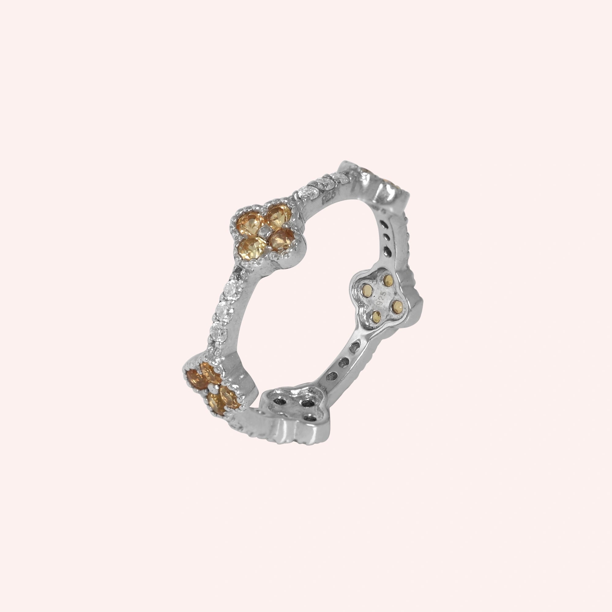 Citrine_ring_gold_plated_silver_floral_band_with_citrine_and_white_topaz_in_slightly_tilted_on_solid_pink_background