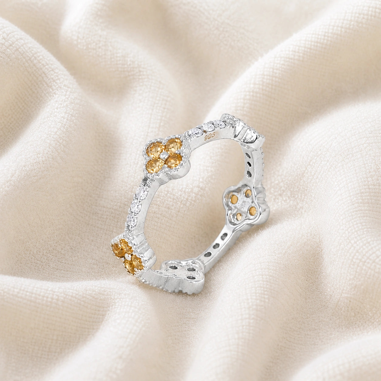Citrine_ring_sterling_silver_floral_band_with_citrine_and_white_topaz_in_slightly_tilted_on_soft_fabric_background