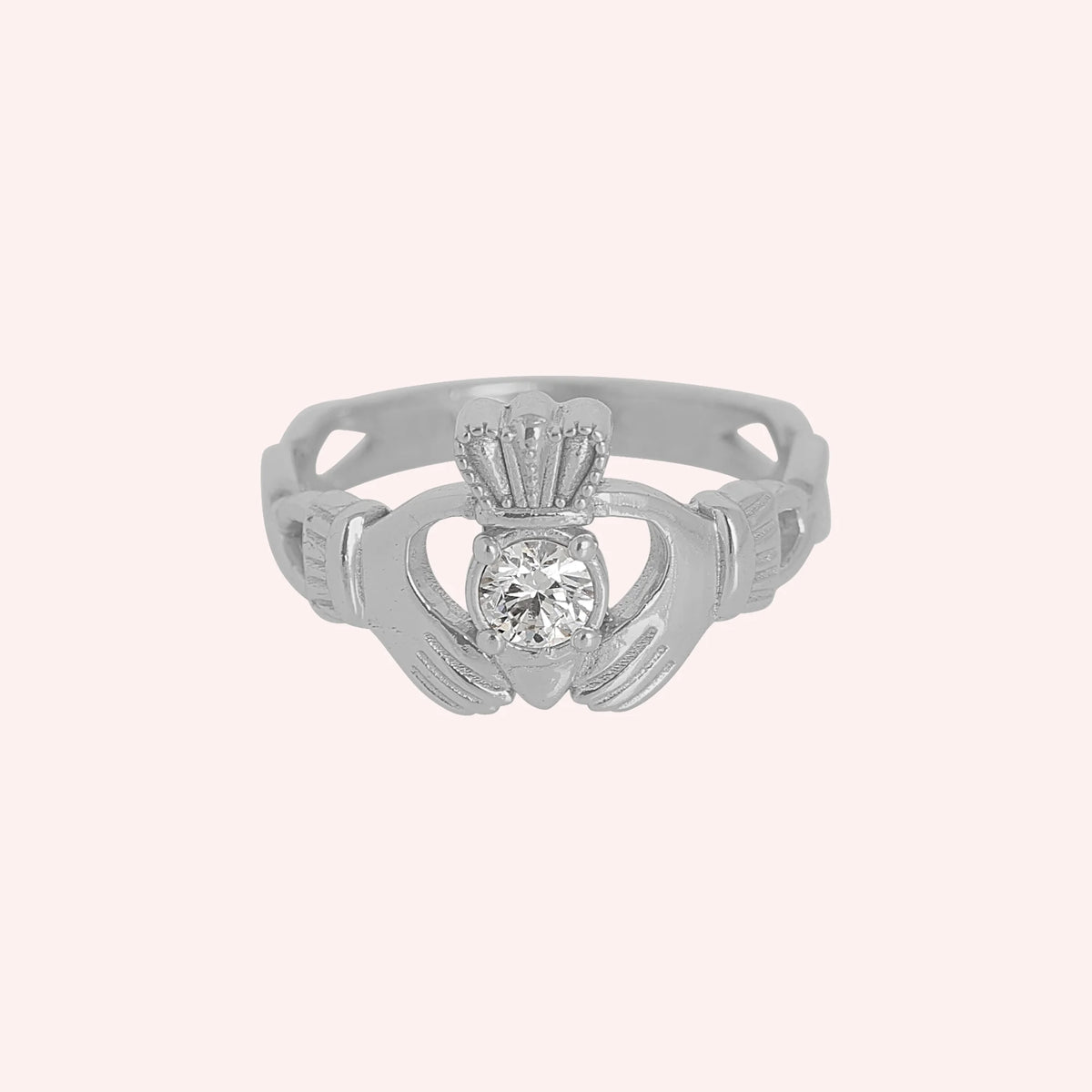 Claddagh_ring_in_sterling_silver_with_a_round_lab_grown_diamond_stone_at_front_angle_view_on_solid_pink_background
