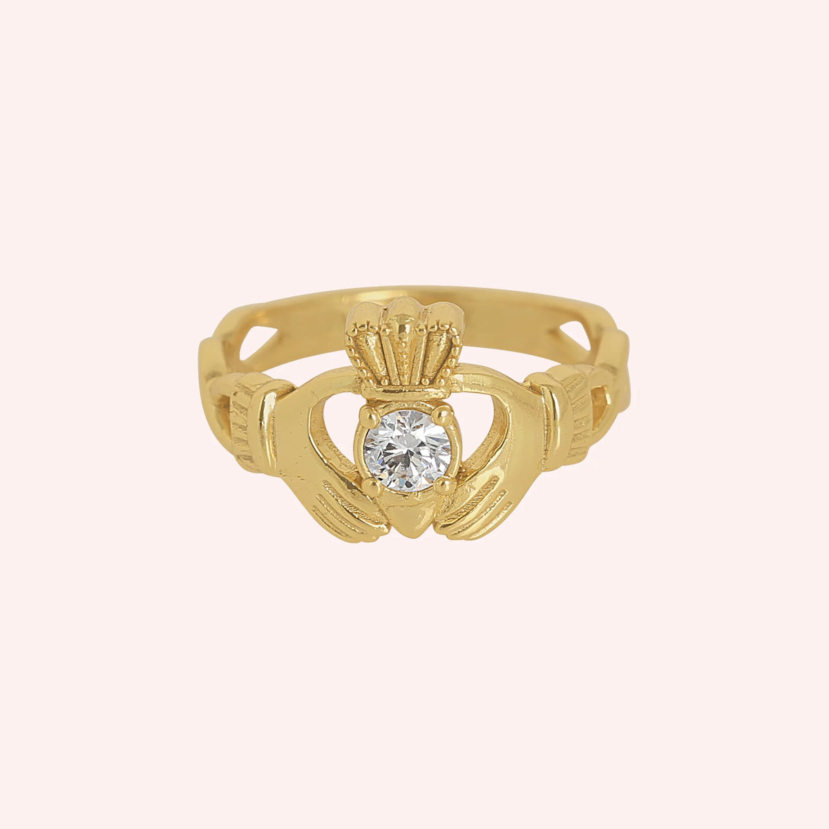 Claddagh_ring_in_gold_plated_silver_with_a_round_lab_grown_diamond_stone_at_front_angle_view_on_solid_pink_background