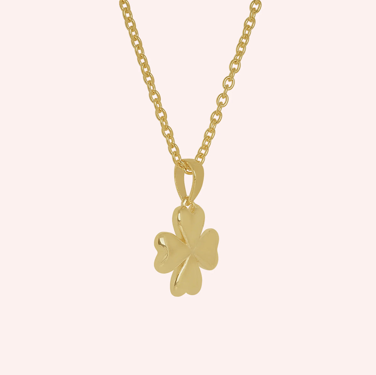 Clover_necklace_in_gold_plated_silver_with_four_leaves_design_at_slight_angle_view_on_solid_pink_background