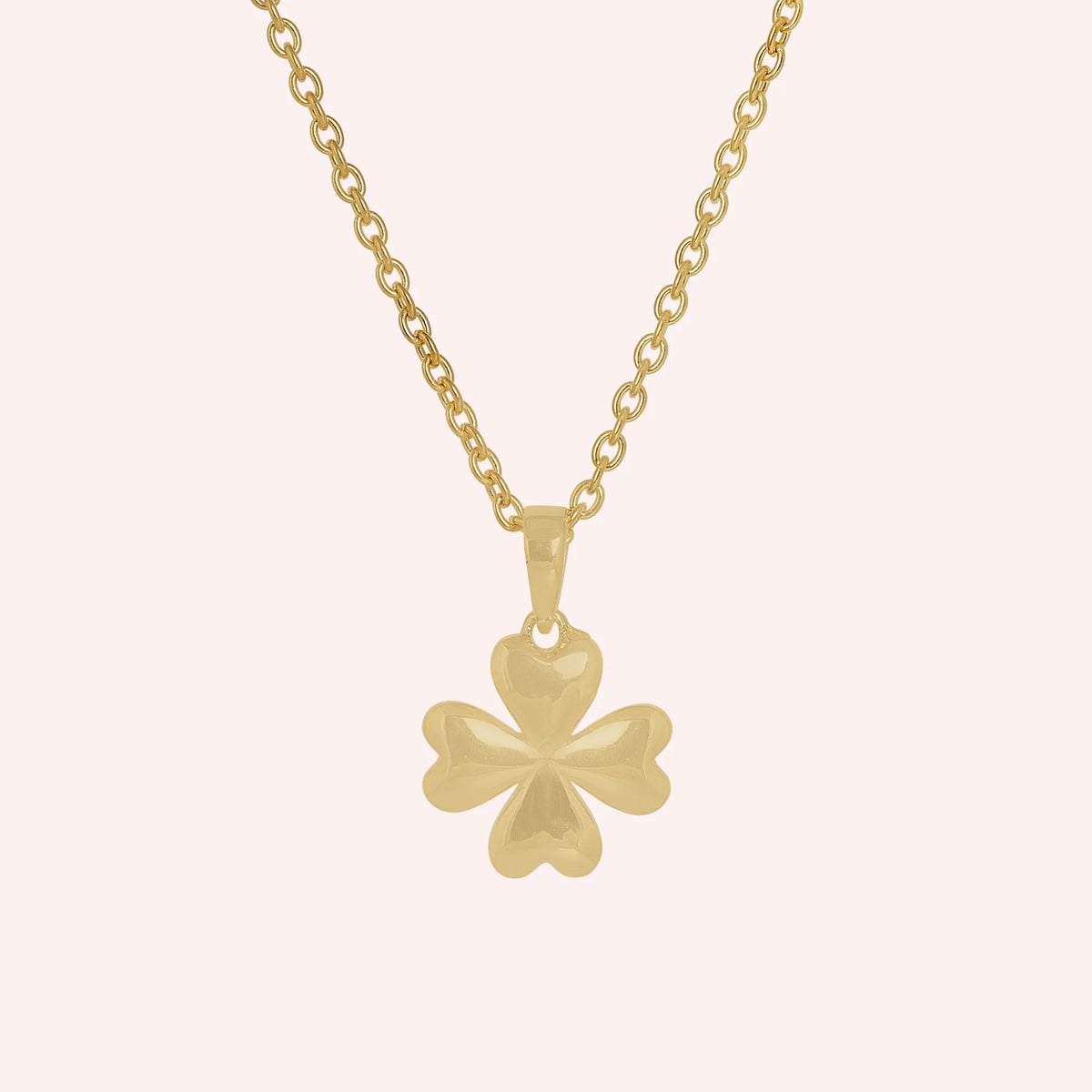 Clover_necklace_in_gold_plated_silver_with_four_leaves_design_at_front_angle_view_on_solid_pink_background