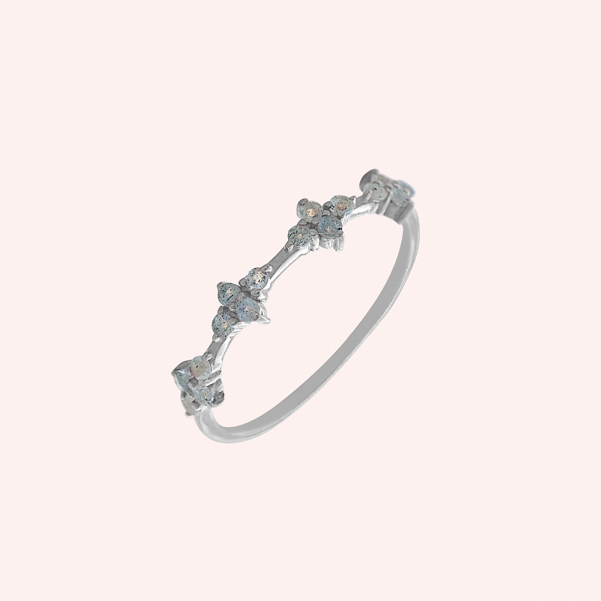 Cluster_ring_sterling_silver_band_with_small_clusters_and_labradorite_stones_slightly_tilted_on_solid_pink_background