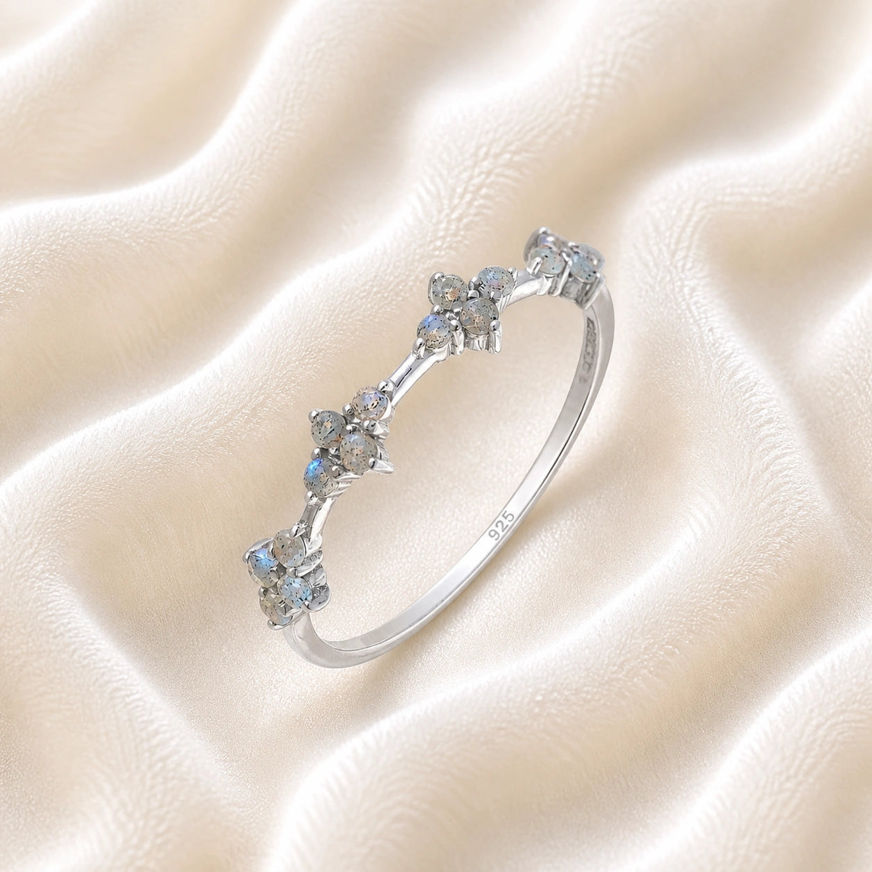 Cluster_ring_sterling_silver_band_with_small_clusters_and_labradorite_stones_slightly_tilted_on_soft_fabric_background