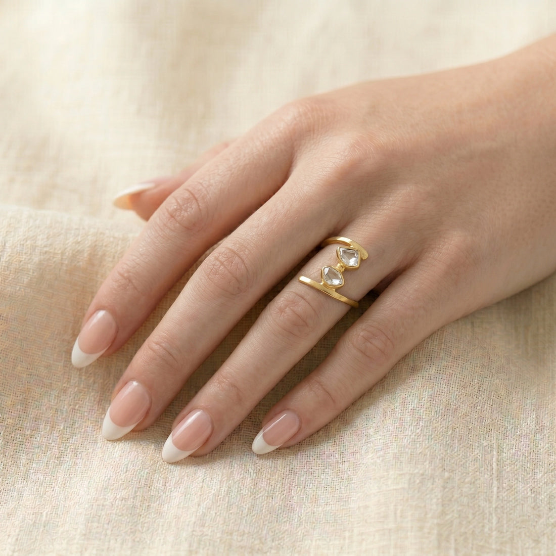 Cocktail_ring_with_open_gold_plated_silver_band_and_two_herkimer_stones_shown_at_front_angle_on_soft_fabric_background