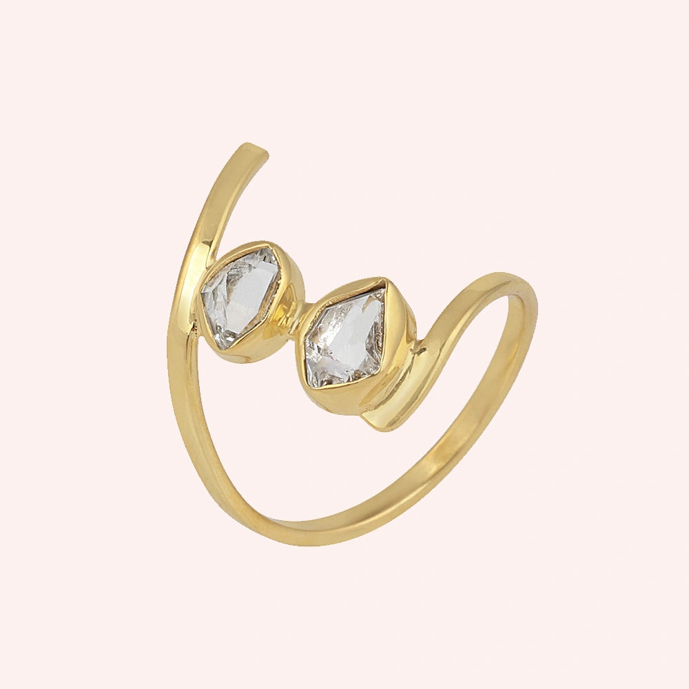 Cocktail_ring_with_open_gold_plated_silver_band_and_two_herkimer_stones_shown_at_slightly_angled_on_solid_pink_background