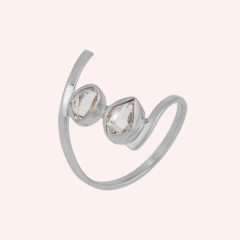Cocktail_ring_with_open_sterling_silver_band_and_two_herkimer_stones_shown_at_slightly_angled_on_solid_pink_background