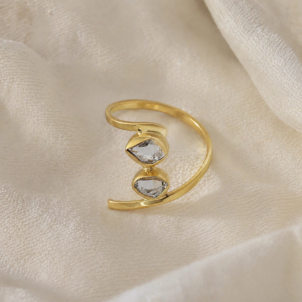 Cocktail_ring_with_open_gold_plated_silver_band_and_two_herkimer_stones_shown_at_front_angle_on_soft_fabric_background
