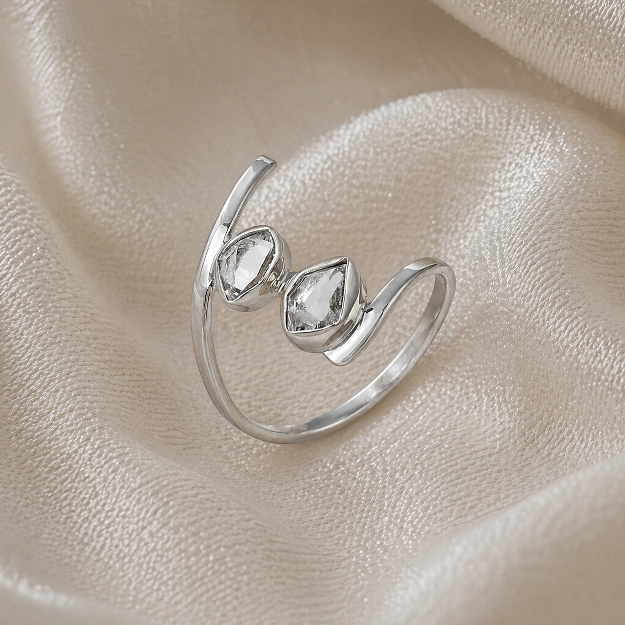 Cocktail_ring_with_open_sterling_silver_band_and_two_herkimer_stones_shown_at_slightly_angled_on_soft_fabric_background
