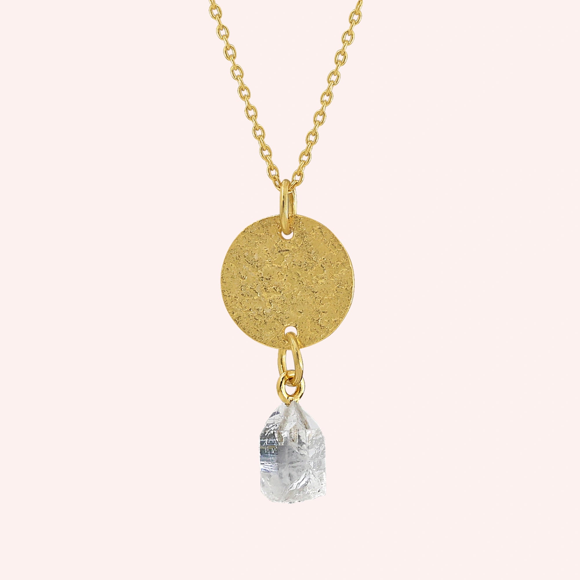 Coin_necklace_in_front_angled_view_with_textured_round_pendant_gold_plated_silver_and_herkimer_stone_on_solid_pink_background