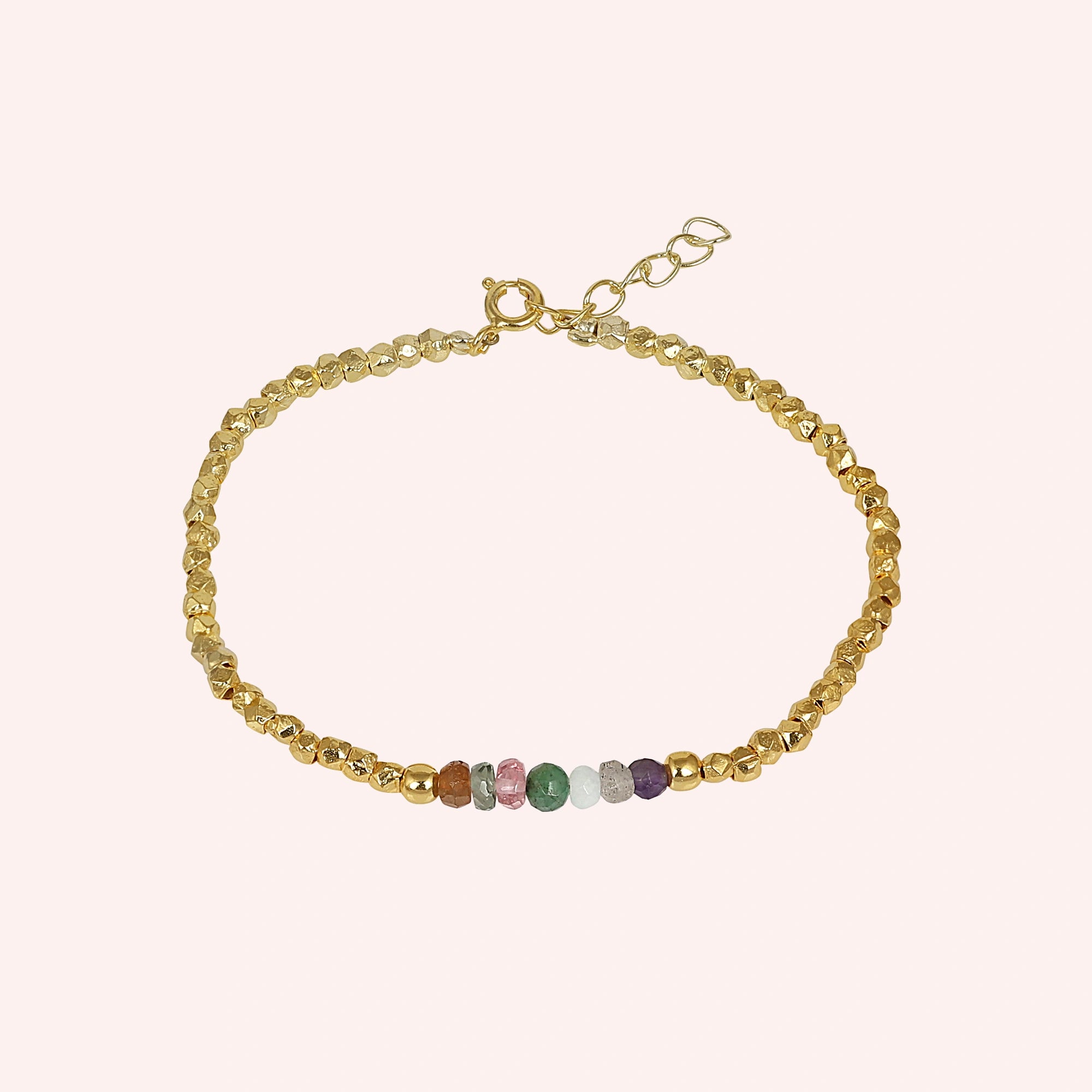 top_angle_colorful_beaded_bracelet_multi_gemstone_bracelet_gold_plated_beads_with_chain_clasp_on_soft_pink_background
