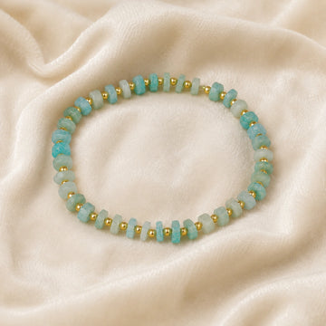 Crystal_bead_bracelet_with_amazonite_stones_and_gold_plated_silver_beads_at_front_angle_view_on_soft_fabric_background