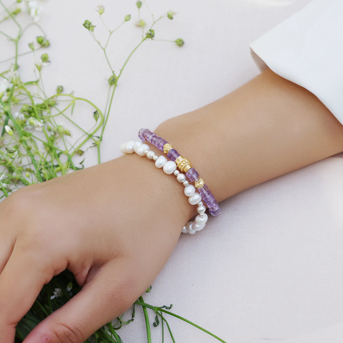 top_angle_crystal_bracelet_with_faceted_amethyst_stones_and_silver_clasp_amethyst_bracelet_on_soft_white_fabric_background