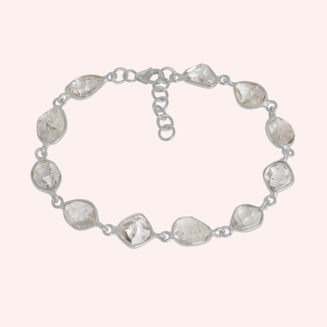 Crystal_bracelet_in_gold_plated_silver_with_raw_herkimer_stones_at_front_angle_view_on_solid_pink_background