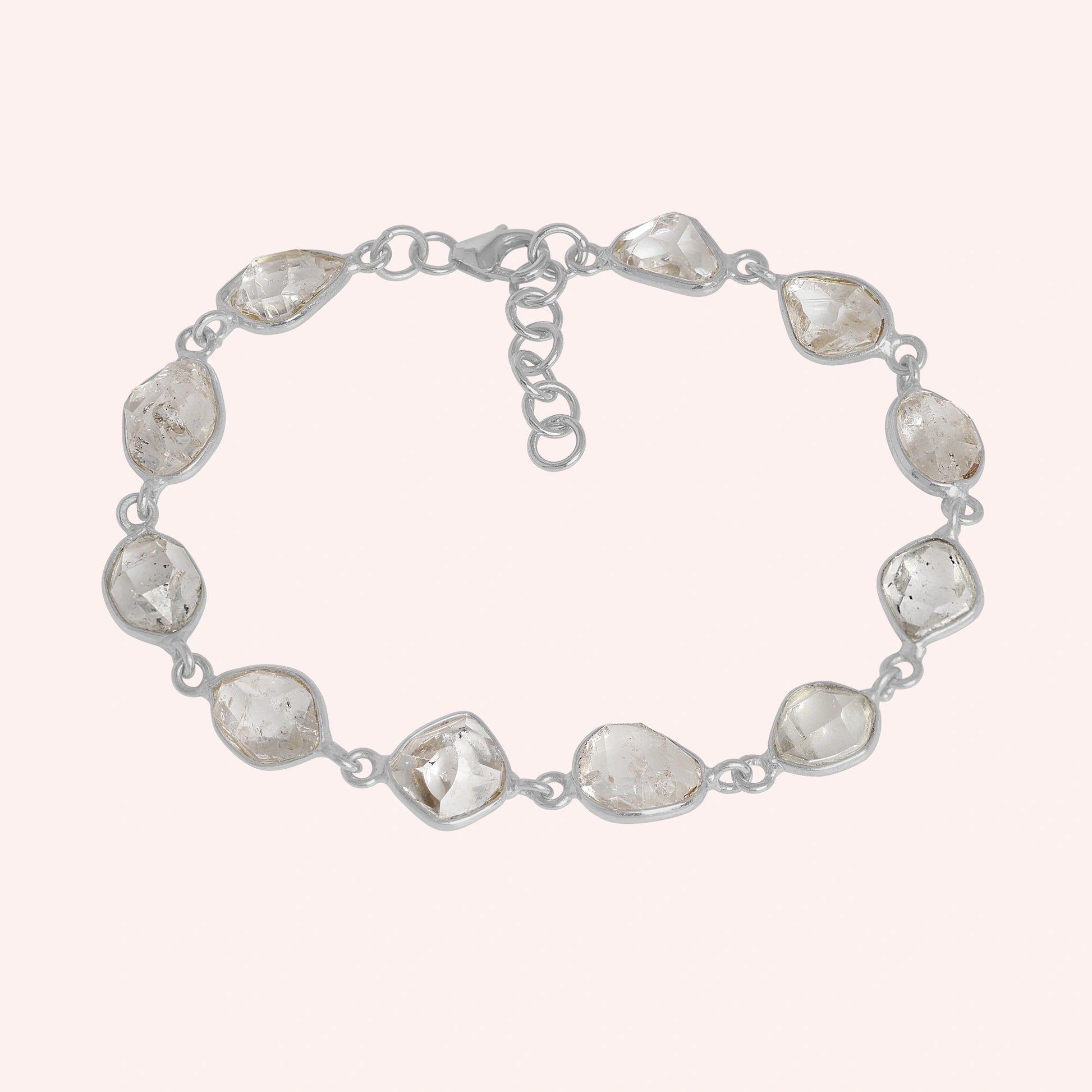 Crystal_bracelet_in_sterling_silver_with_raw_herkimer_stones_at_front_angle_view_on_solid_pink_background