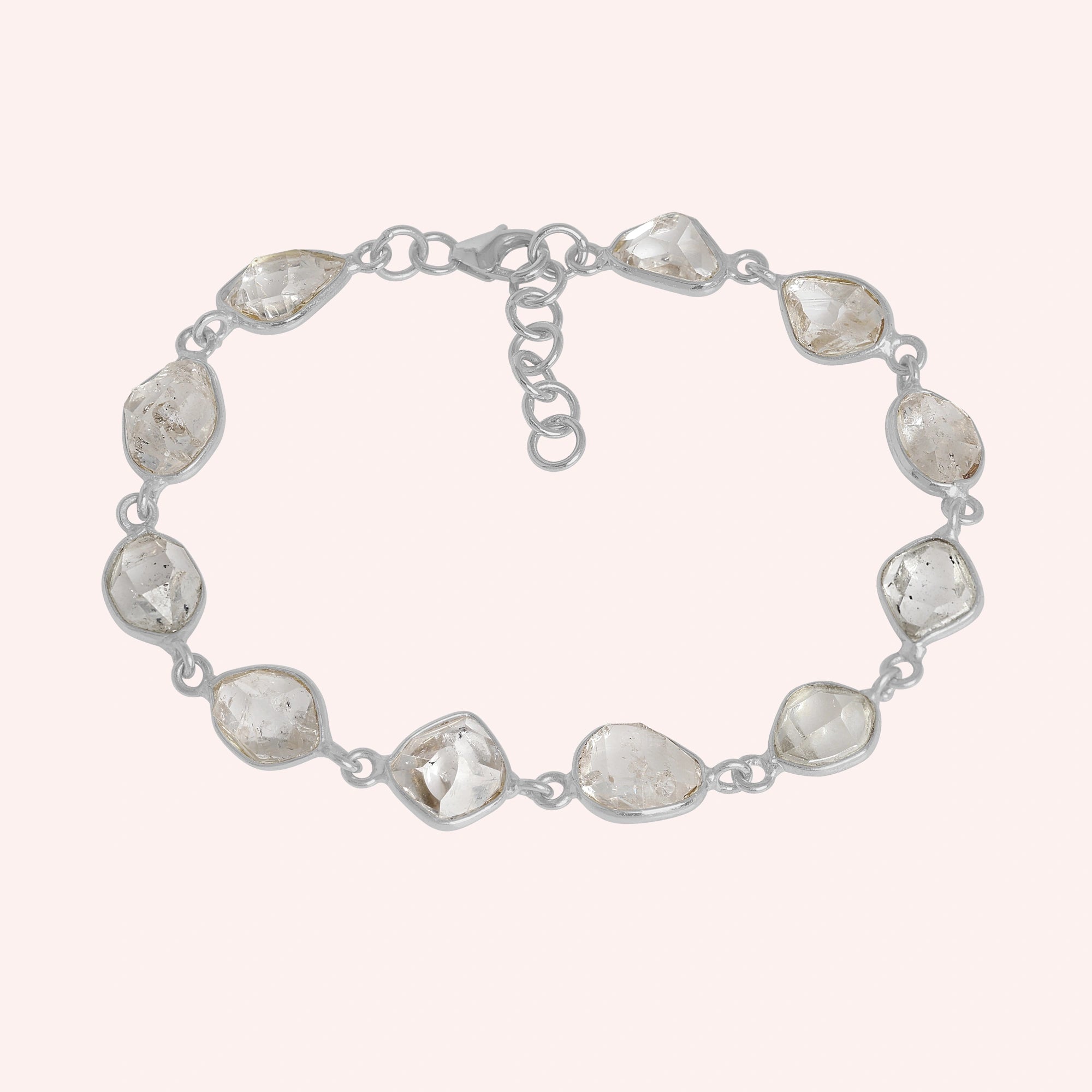 Crystal_bracelet_in_sterling_silver_with_raw_herkimer_stones_at_front_angle_view_on_solid_pink_background