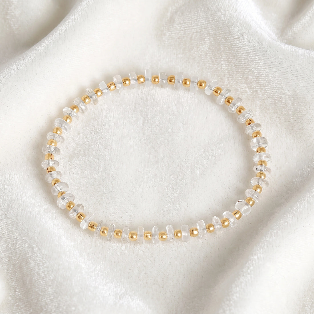 Crystal_bracelet_with_crystal_and_gold_plated_silver_beads_at_front_angle_view_on_soft_fabric_background