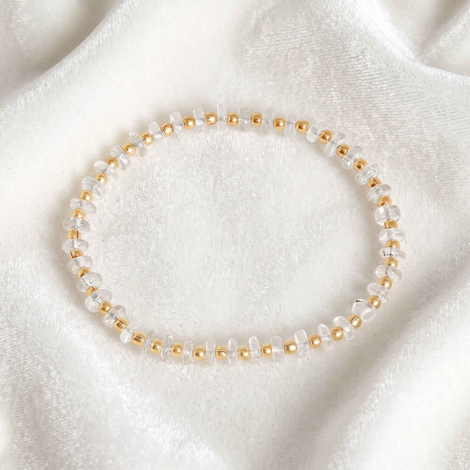 Crystal_bracelet_with_crystal_and_gold_plated_silver_beads_at_front_angle_view_on_soft_fabric_background