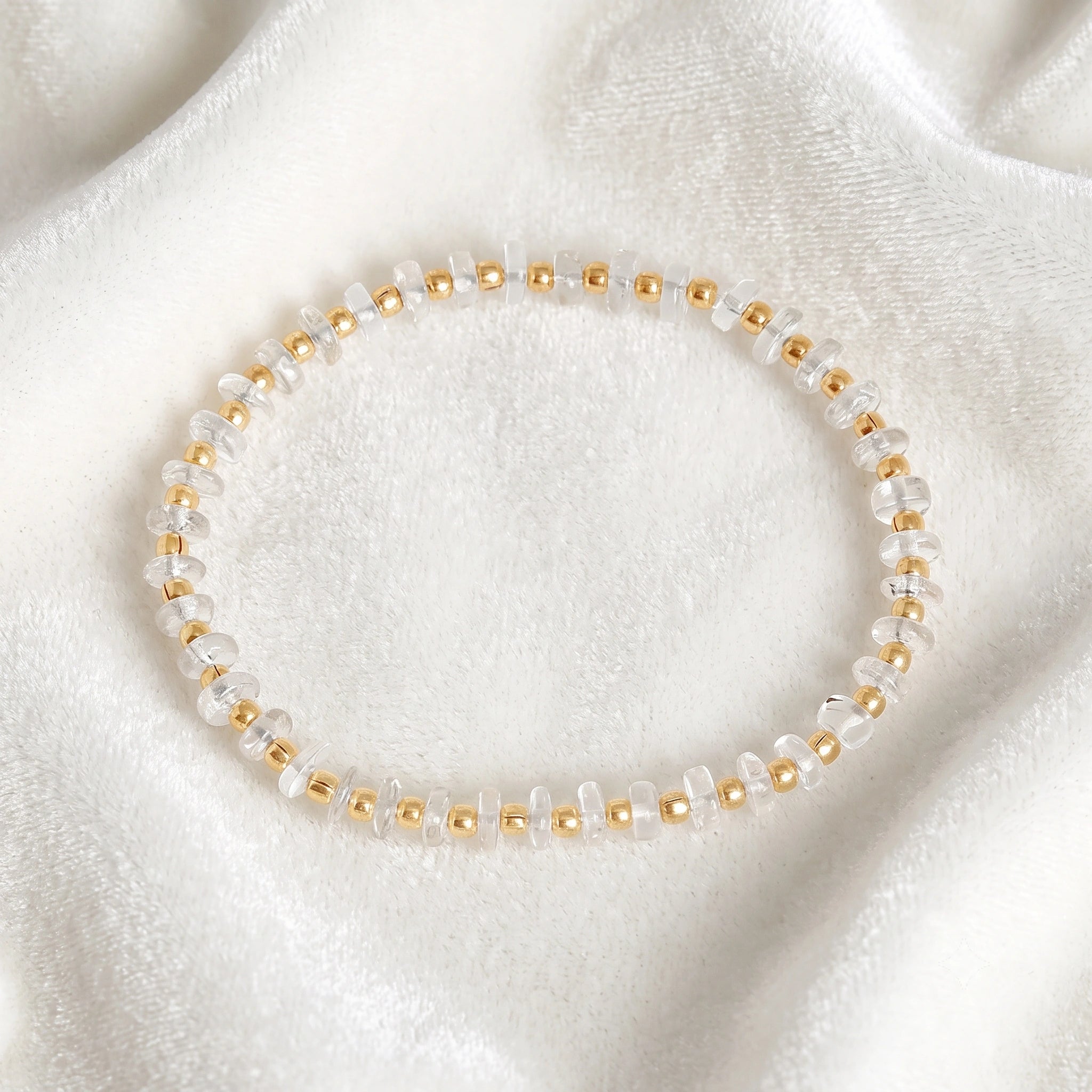 Crystal_bracelet_with_crystal_and_gold_plated_silver_beads_at_front_angle_view_on_soft_fabric_background