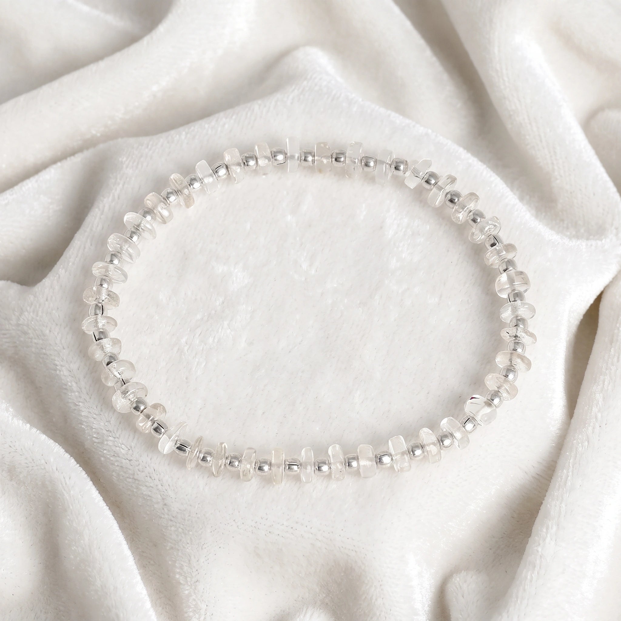 Crystal_bracelet_with_crystal_and_sterling_silver_beads_at_front_angle_view_on_soft_fabric_background