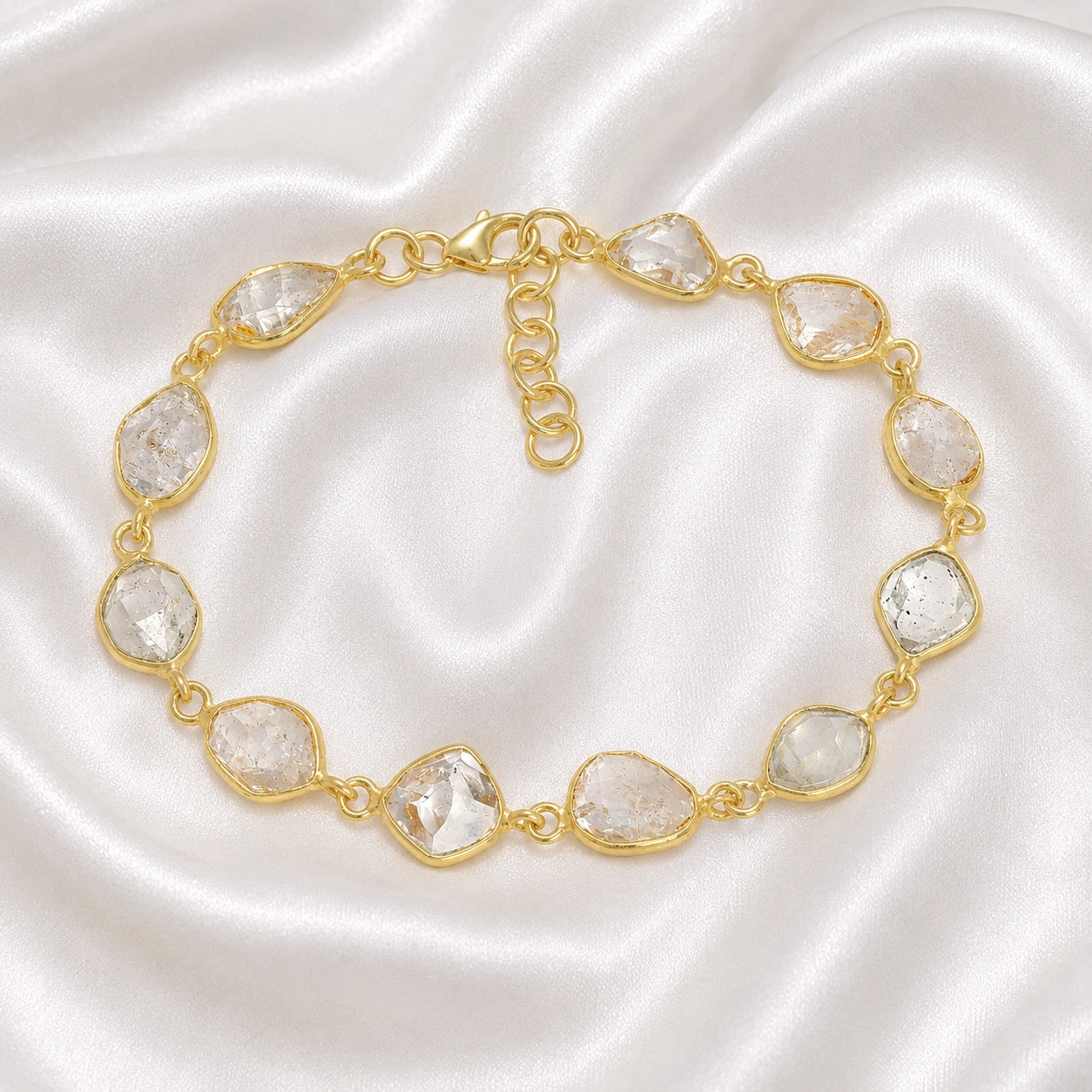 Crystal_bracelet_in_gold_plated_silver_with_raw_herkimer_stones_at_front_angle_view_on_soft_fabric_background