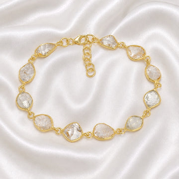 Crystal_bracelet_in_gold_plated_silver_with_raw_herkimer_stones_at_front_angle_view_on_soft_fabric_background