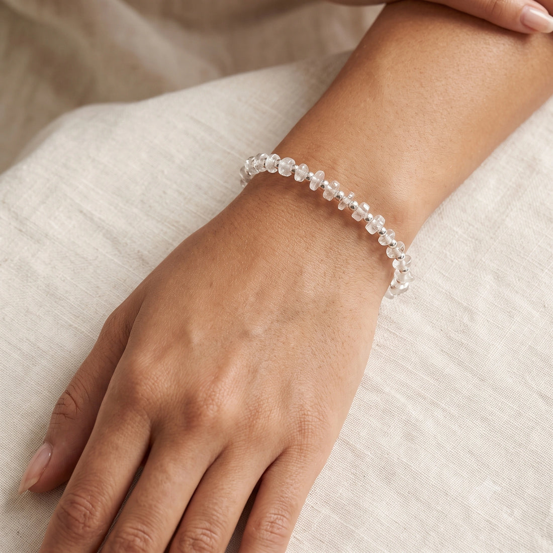 Crystal_bracelet_with_crystal_and_gold_plated_silver_beads_at_front_angle_view_on_soft_fabric_background