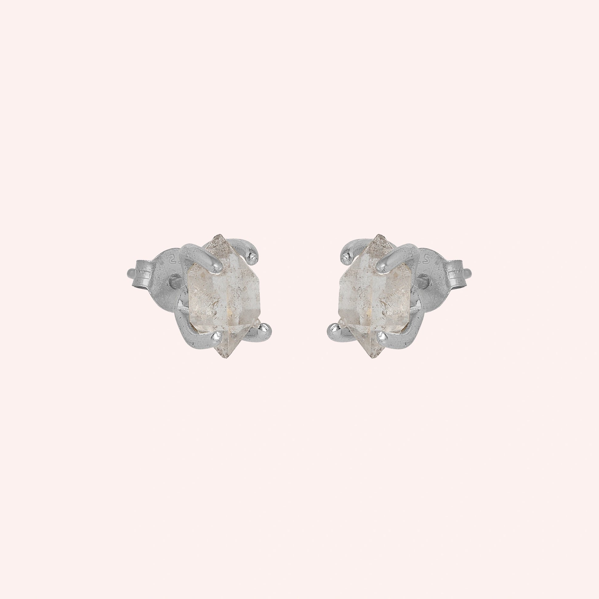 Crystal_earrings_in_sterling_silver_with_raw_herkimer_stone_at_slight_angle_view_on_solid_pink_background