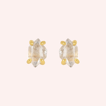 Crystal_earrings_in_gold_plated_silver_with_raw_herkimer_stone_at_front_angle_view_on_solid_pink_background