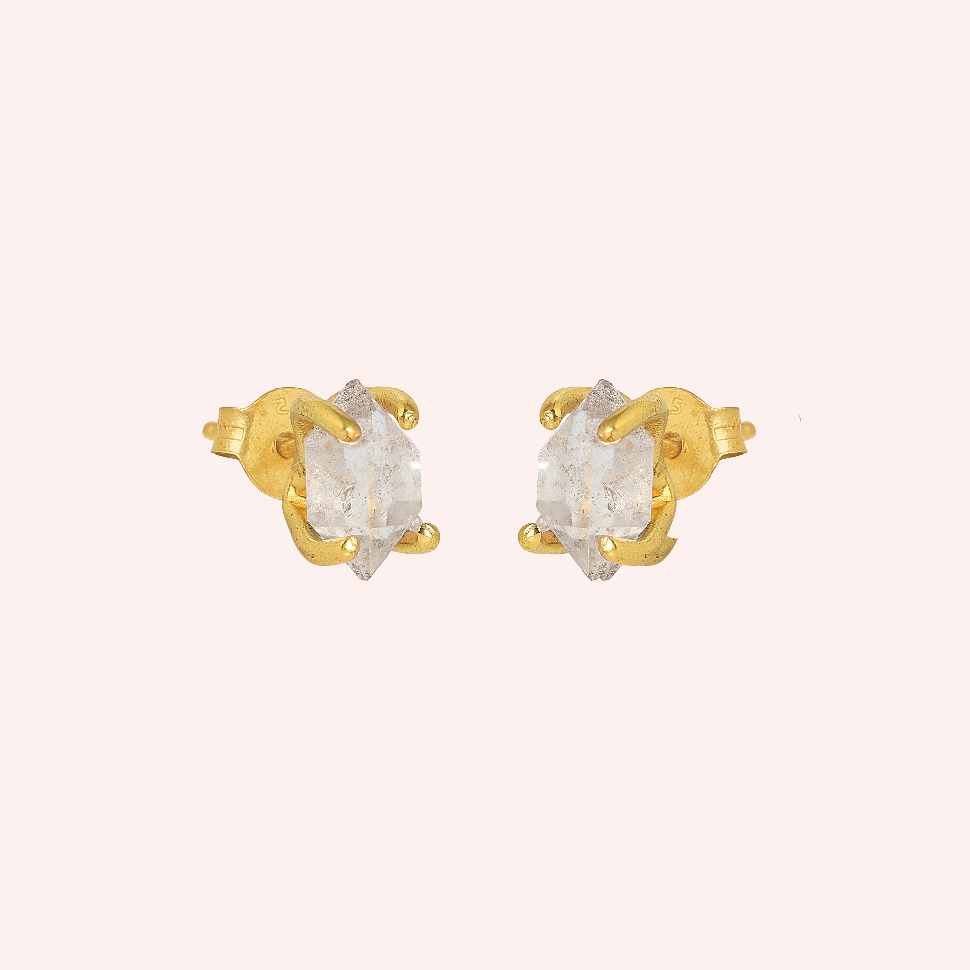 Crystal_earrings_in_gold_plated_silver_with_raw_herkimer_stone_at_slight_angle_view_on_solid_pink_background