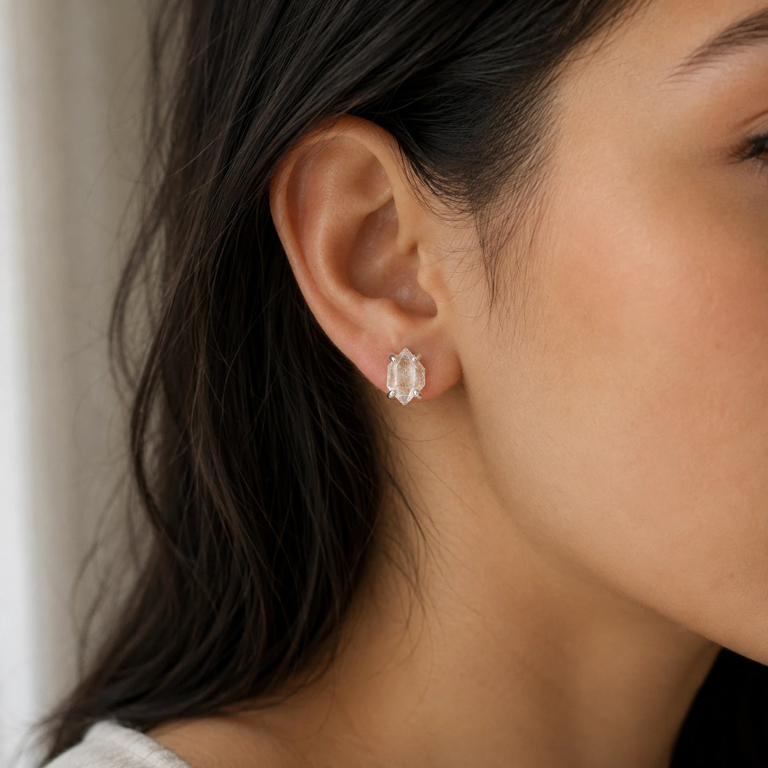 Crystal_earrings_in_gold_plated_silver_with_raw_herkimer_stone_at_slight_angle_view_on_soft_fabric_background